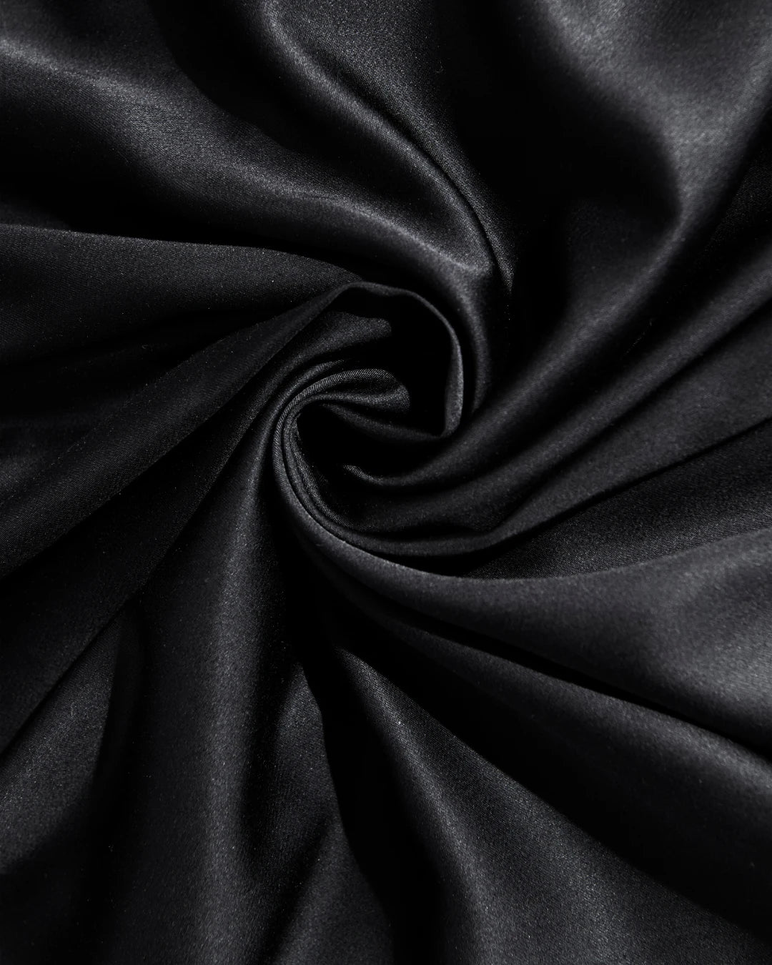 Close-up of black satin fabric with folds