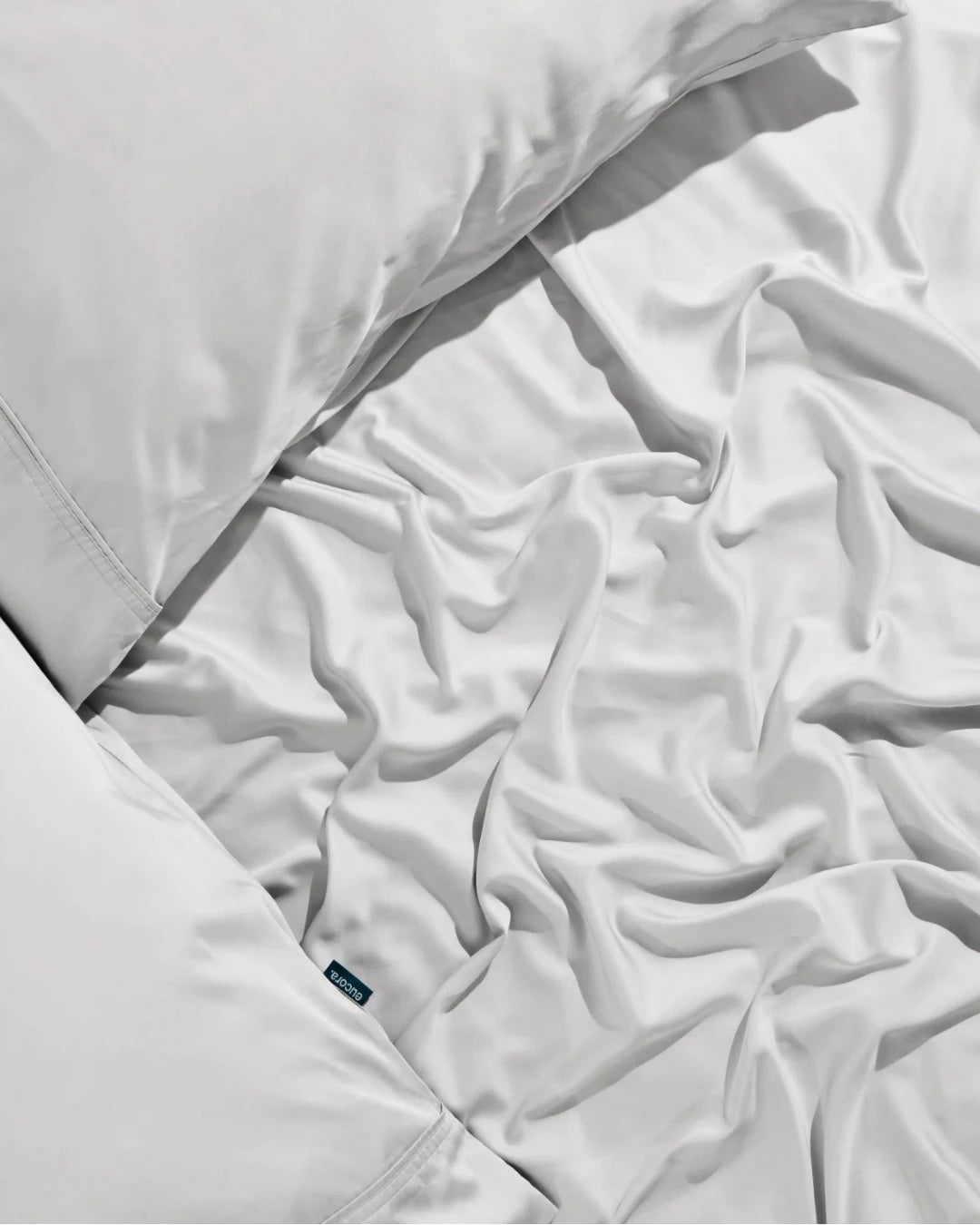 Close-up of white bedding with a visible brand label.