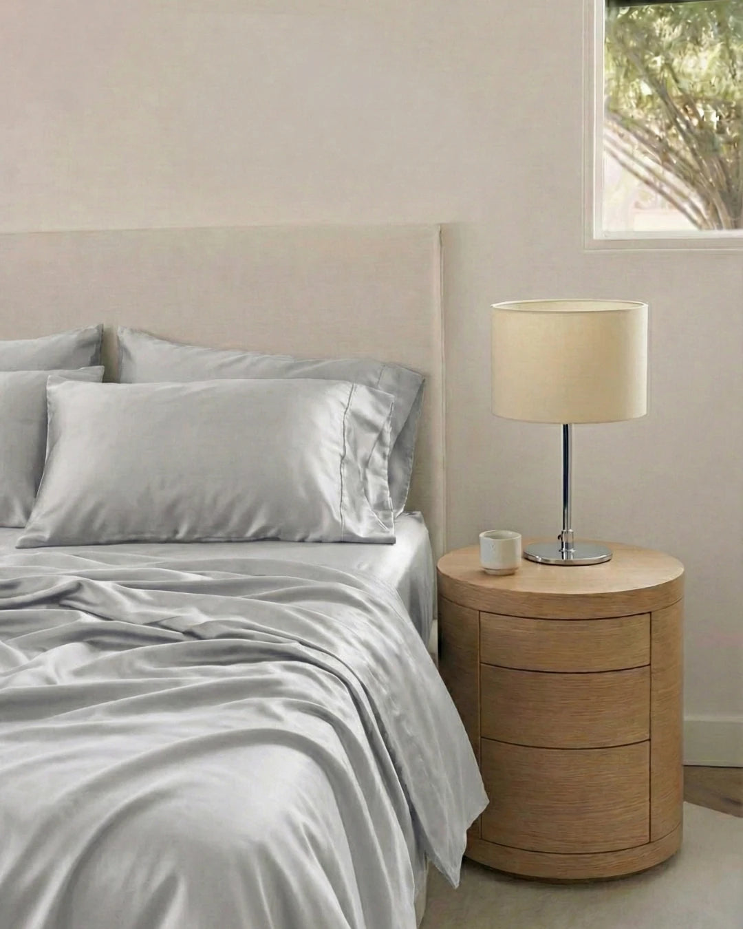Bedroom with a bed and wooden nightstand featuring a lamp.