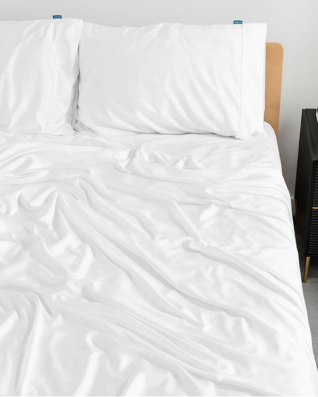 White bedding set on a bed with a plain background