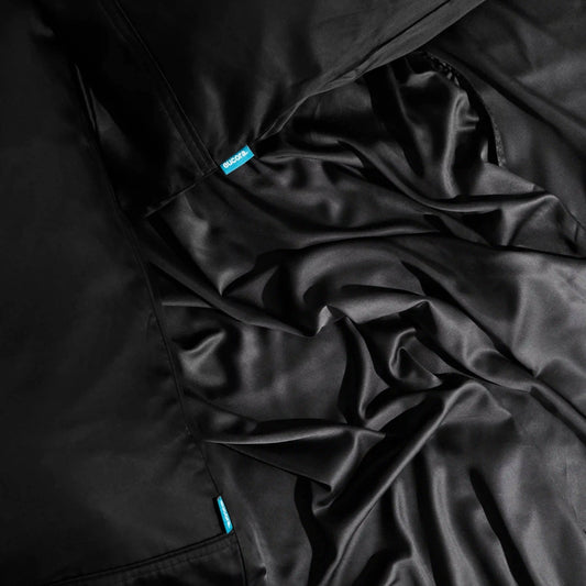 Close-up of black fabric with a brand label on a dark background