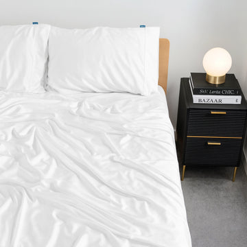 Luxury white bamboo bed sheets infused with eucalyptus oil, styled on a modern bed. Soft, cooling, and breathable bedding set for hot sleepers in Australia and the UK.