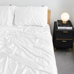 White bamboo bed sheets on a bed with a nightstand in the background by Eucora