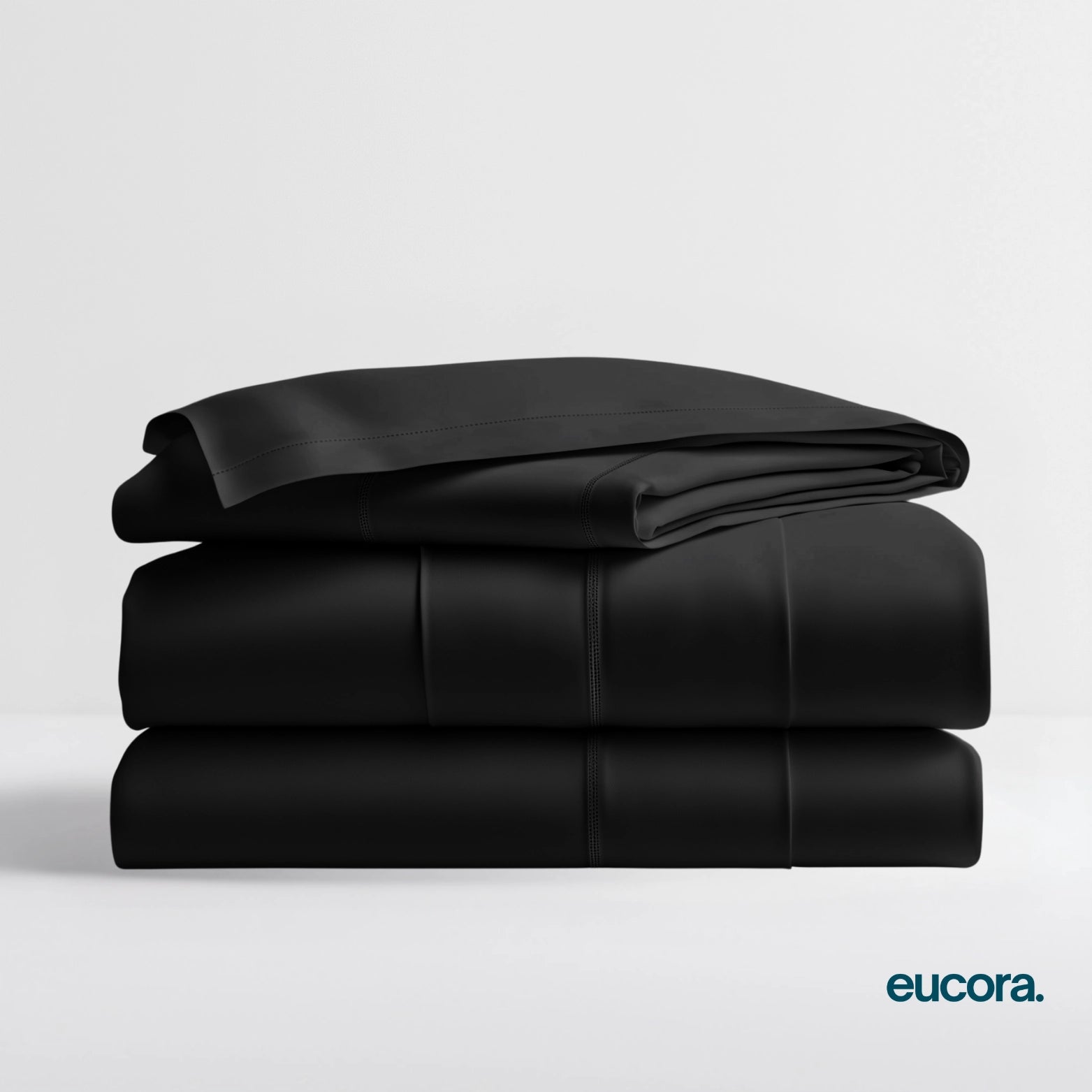 Charcoal eucalyptus-infused bamboo bed sheets by Eucora stacked neatly to highlight their rich color, buttery-soft texture, and luxurious feel.